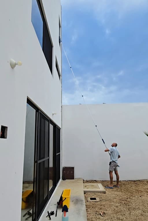 Qtana cleaner using an extension pole to reach exterior windows