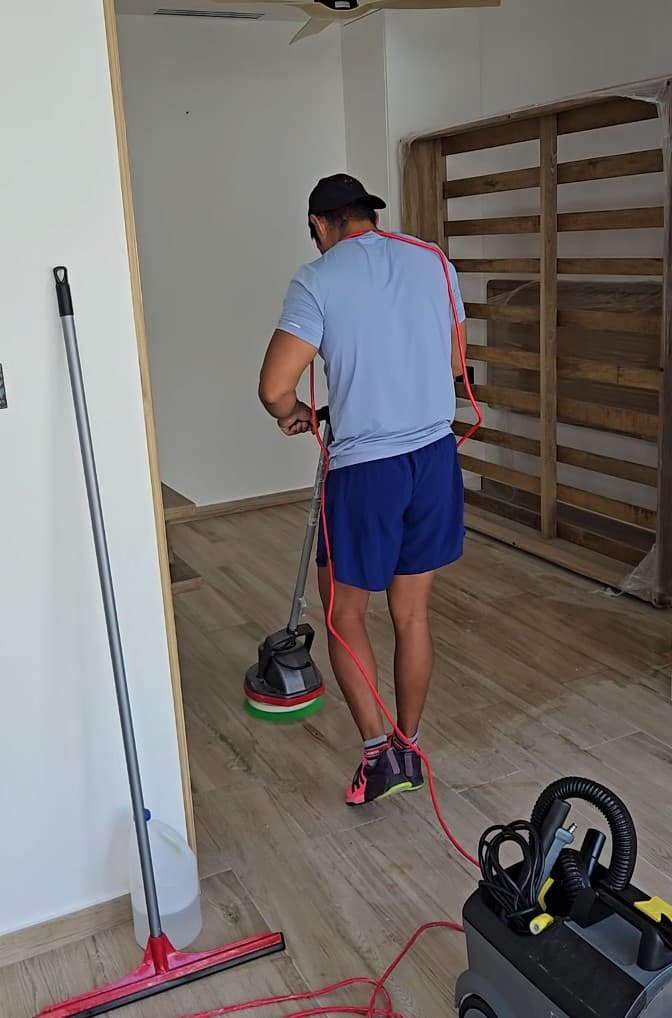 Qtana cleaner using a floor polisher on a wood floor