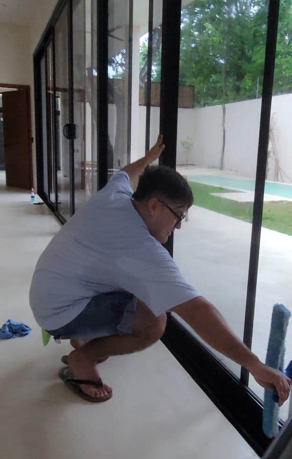 Qtana cleaner squeegeeing a glass sliding door