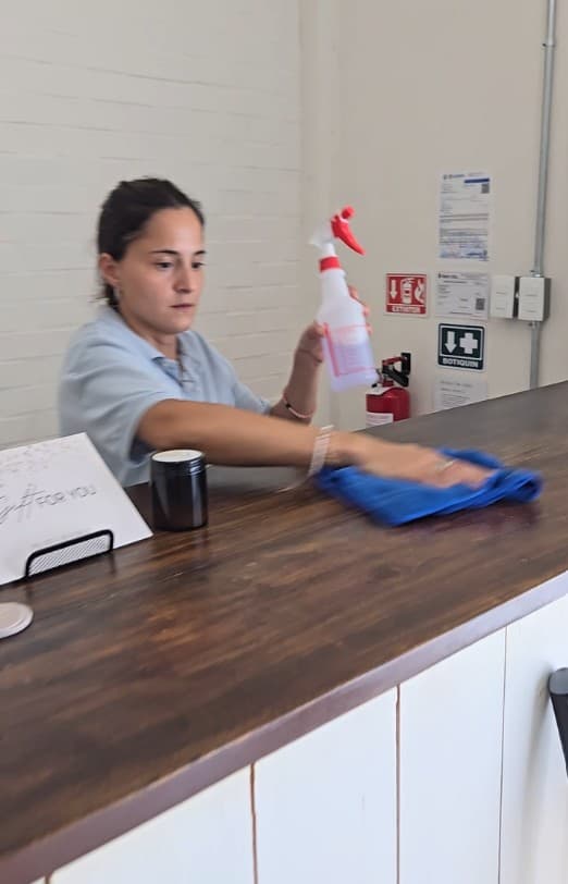 Qtana cleaner wiping a wood counter with a microfiber cloth